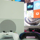 The Xbox One S and its controllers in front of a TV.
